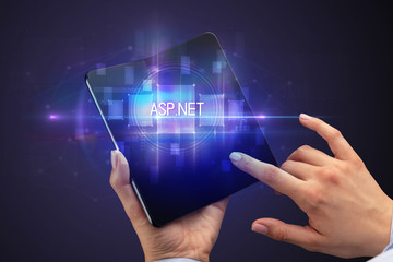 Businessman holding a foldable smartphone with ASP.NET inscription, new technology concept