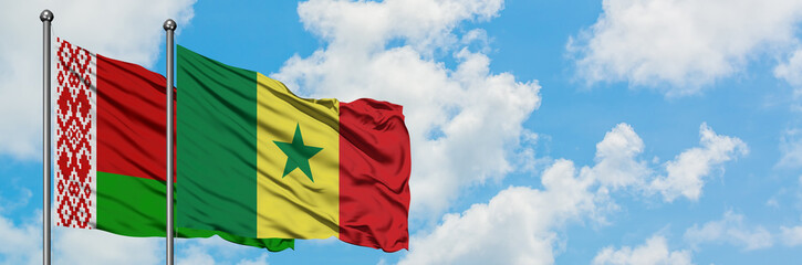 Fototapeta na wymiar Belarus and Senegal flag waving in the wind against white cloudy blue sky together. Diplomacy concept, international relations.