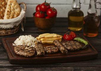 grilled beef kebabs served with rice, french fries, grilled tomato and pepper
