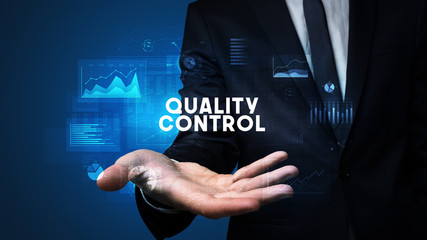 Hand of Businessman holding QUALITY CONTROL inscription, business success concept