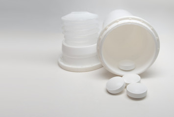 Tablets scattered on the table and packaging from them in the background, on a white background.