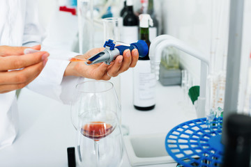 Fototapeta premium Hands working in chemical laboratory checking wine qualities