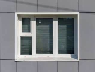 White plastic window on a gray wall. Theme of construction, repair and glazing