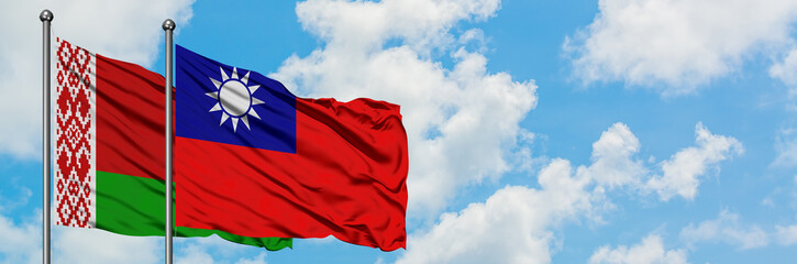 Naklejka premium Belarus and Taiwan flag waving in the wind against white cloudy blue sky together. Diplomacy concept, international relations.