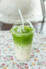 Iced Matcha green tea frappuccino in takeaway cup. Glass of green tea smoothies with fresh green tea. Homemade Iced Matcha Latte Tea with Milk.