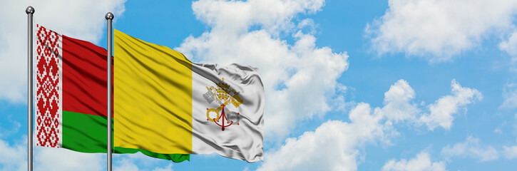 Belarus and Vatican City flag waving in the wind against white cloudy blue sky together. Diplomacy concept, international relations.