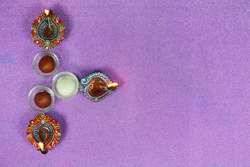 Deepawali Diwali Celebrations with Three Diya and Sweets Purple Background