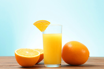Orange juice in a glass, oranges and orange slices on the table.