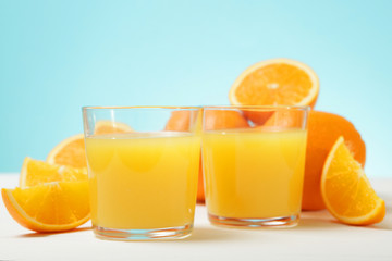 Orange juice in a glass, oranges and orange slices on the table.