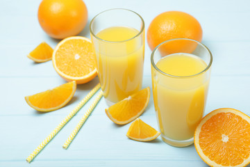 Orange juice in a glass, oranges and orange slices on the table.