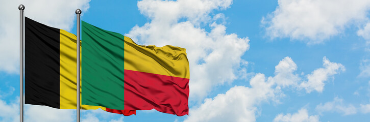 Obraz premium Belgium and Benin flag waving in the wind against white cloudy blue sky together. Diplomacy concept, international relations.