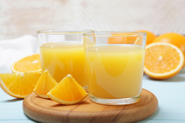 Orange juice in a glass, oranges and orange slices on the table.