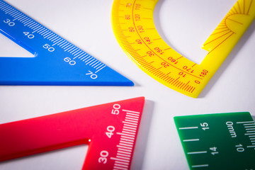 Concept image of colourful rulers and protractor in white background.