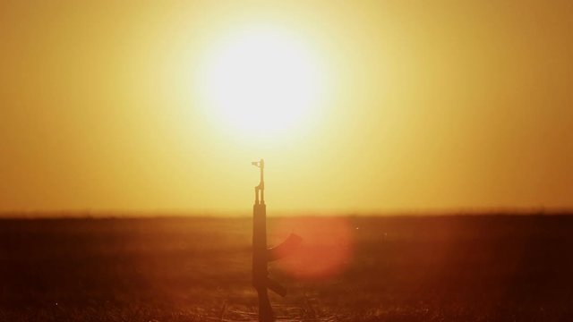 Kalashnikov assault rifle in the desert after the battle. Kalashnikov assault rifle at sunset in the desert.