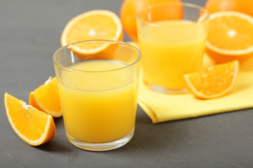 Orange juice in a glass, oranges and orange slices on the table.