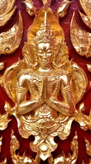 Golden carved Buddha on the door of a Thai temple