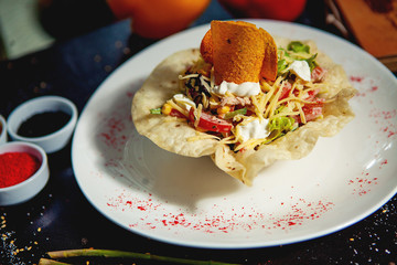 vegetable salad in crusty flatbread bowl with cheese, tomato and lettuce