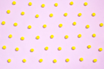 Yellow pompom polka dots pattern on pastel pink background