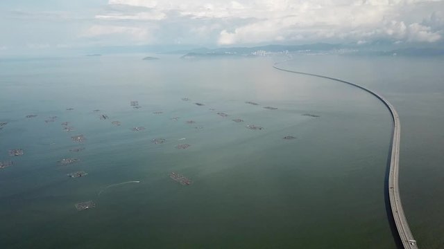Aerial boat sail in fish farm. Car move at highway Sultan Abdul Halim Muadzam Shah Bridge