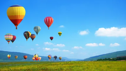 Schilderijen op glas Hot Air balloons flying over mountain landscape background. © applezoomzoom