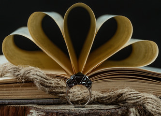 a ring with burgundy stones in front of open book, rustic style