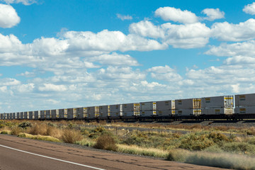 Long row of railroad cars traveling through the desert southwest