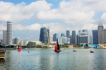 Fototapeta premium Singapore, Marina Bay. Skyscrapers. Beautiful pedestrian promenade in the heart of Singapore, with many bars, shops and restaurants. In the evening, all around in the lights of skyscrapers. 