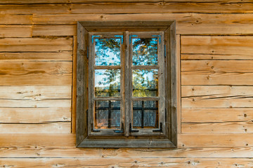 Obraz na płótnie Canvas village house window frame with colorful reflection from nature and wooden deck wall exterior background 