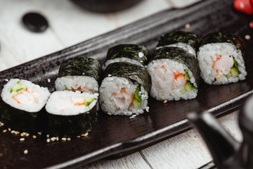 close up of nori rolls with shrimp, cucumber and rice