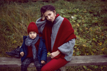 Fototapeta premium mom and son sitting on a street bench