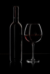 bottle and wine glass with red wine