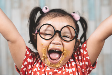 cute little girl with mouth smeared with peanut butter. Concept of penut butter lover