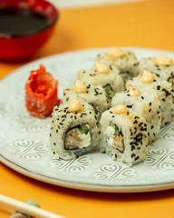 close up of sushi rolls with shrimp, cucumber covered with sesame