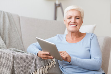 Old woman using digital tablet, chatting with family