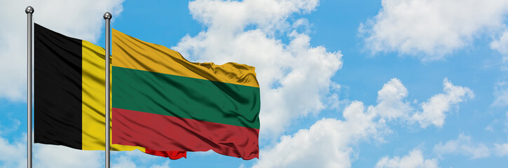 Belgium and Lithuania flag waving in the wind against white cloudy blue sky together. Diplomacy concept, international relations.