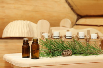 Bottles with healing essential oil for sauna near green pine branch. The concept of natural aromatherapy and spa treatment.