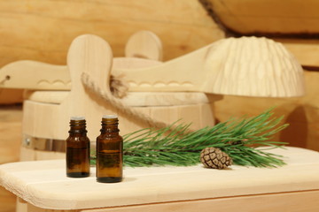 Bottles with healing essential oil for sauna near green pine branch. The concept of natural aromatherapy and spa treatment.