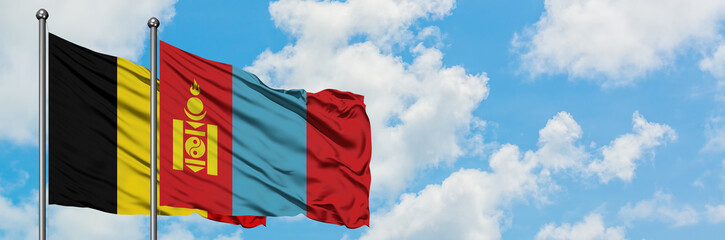 Naklejka premium Belgium and Mongolia flag waving in the wind against white cloudy blue sky together. Diplomacy concept, international relations.