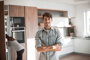 Obraz premium handsome young man standing in his kitchen.