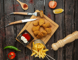 top view of chicken nuggets served with ketchup, mayonnaise and french fries