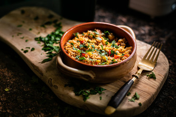 A bowl of paella in wood
