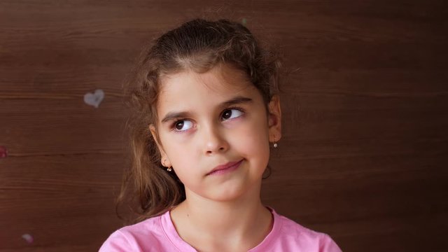 The girl child spits on the palm of the fallen tooth and shows a toothless smile. First lost milk teeth.