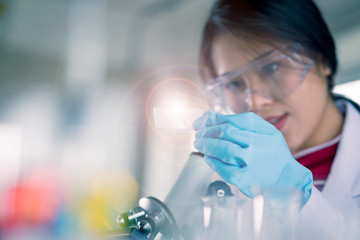 Young Asian medical technologist female making testing with test tube while doing research in science laboratory