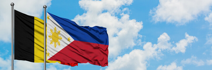 Belgium and Philippines flag waving in the wind against white cloudy blue sky together. Diplomacy concept, international relations.