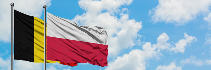 Belgium and Poland flag waving in the wind against white cloudy blue sky together. Diplomacy concept, international relations.