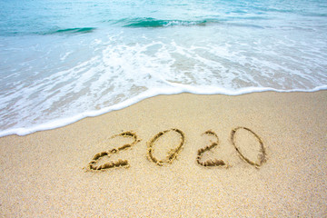 New Year 2020 on the sandy shore against the backdrop of sea waves.