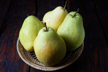 Group of pears on a dark wooden background. Organic foods, healthy nutrition.