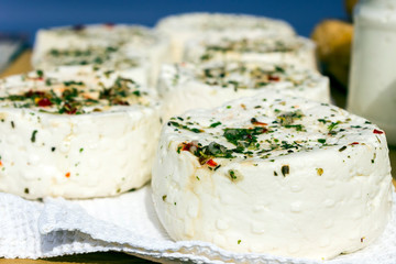 Large selection of cheese varieties on a wooden table background.