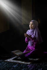 Muslim women wearing purple shirts Doing prayer According to the principles of Islam..