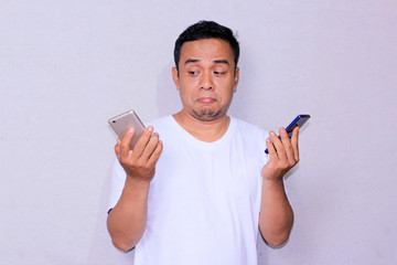 young Asian man's expression by folding his lips indicates confusion between accepting or rejecting...